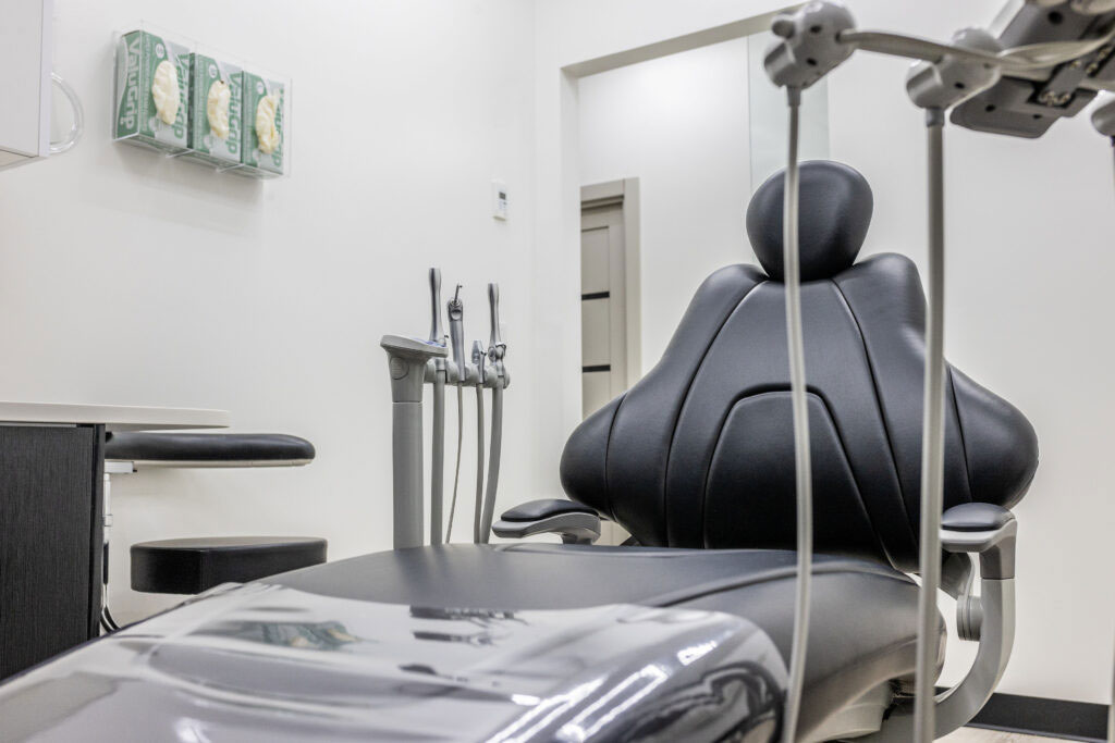 Empty Dental Chair With Overhead Light And Instruments In Clean Modern Treatment Room