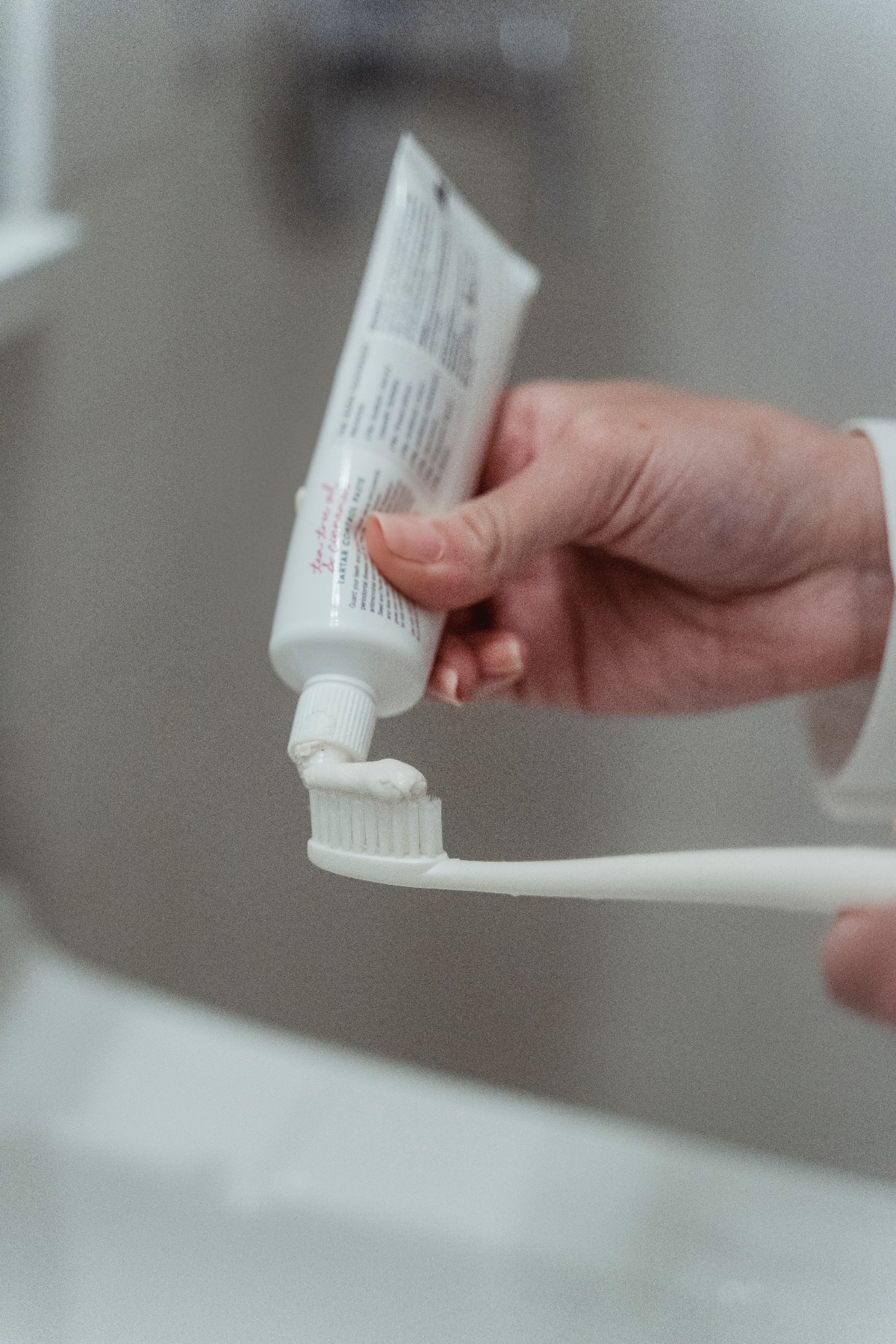 Photo Hand Applying Toothpaste Onto Toothbrush Bristles In Bathroom Converted