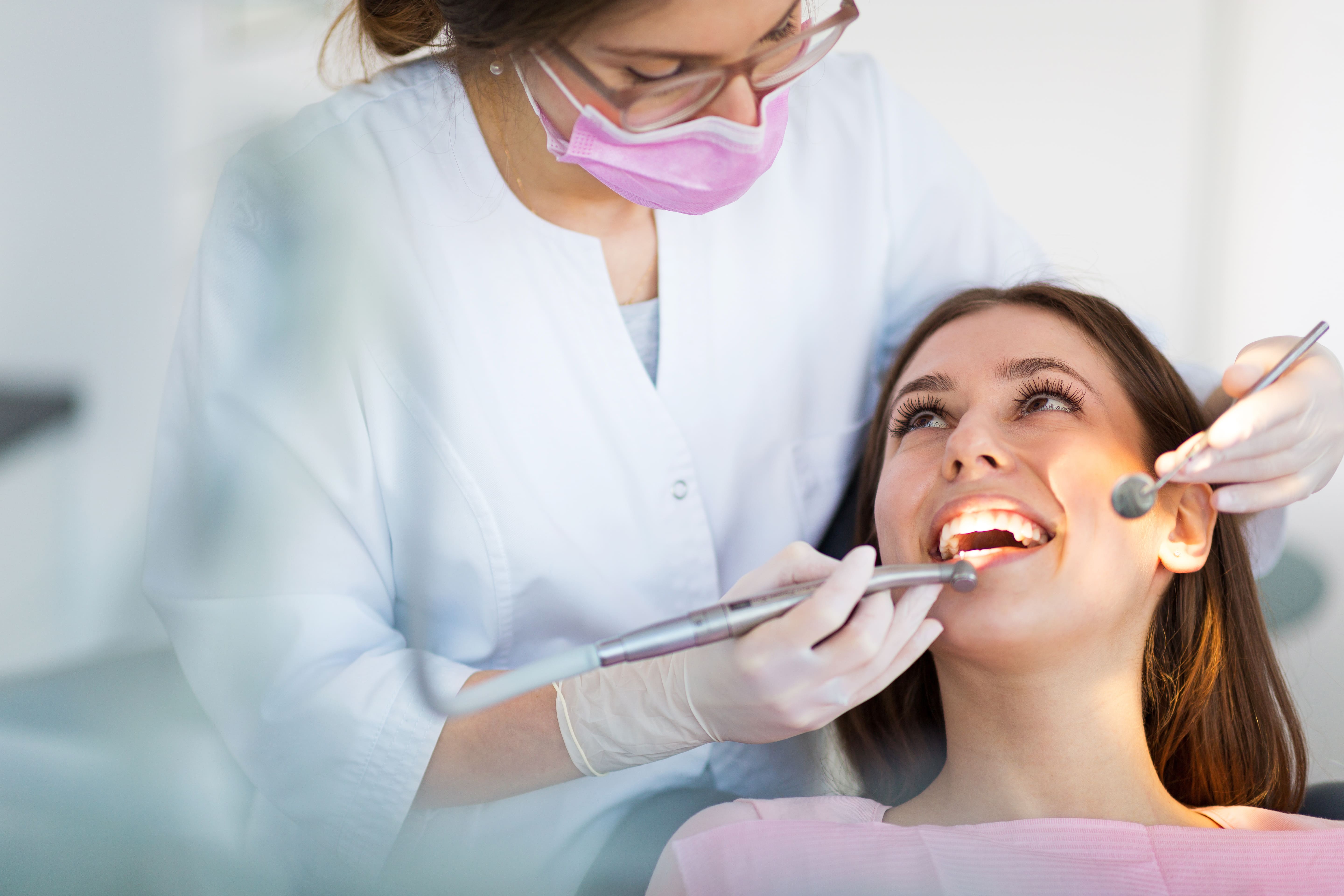 Photo Dentist Examining Patient Teeth With Dental Tools Smiling