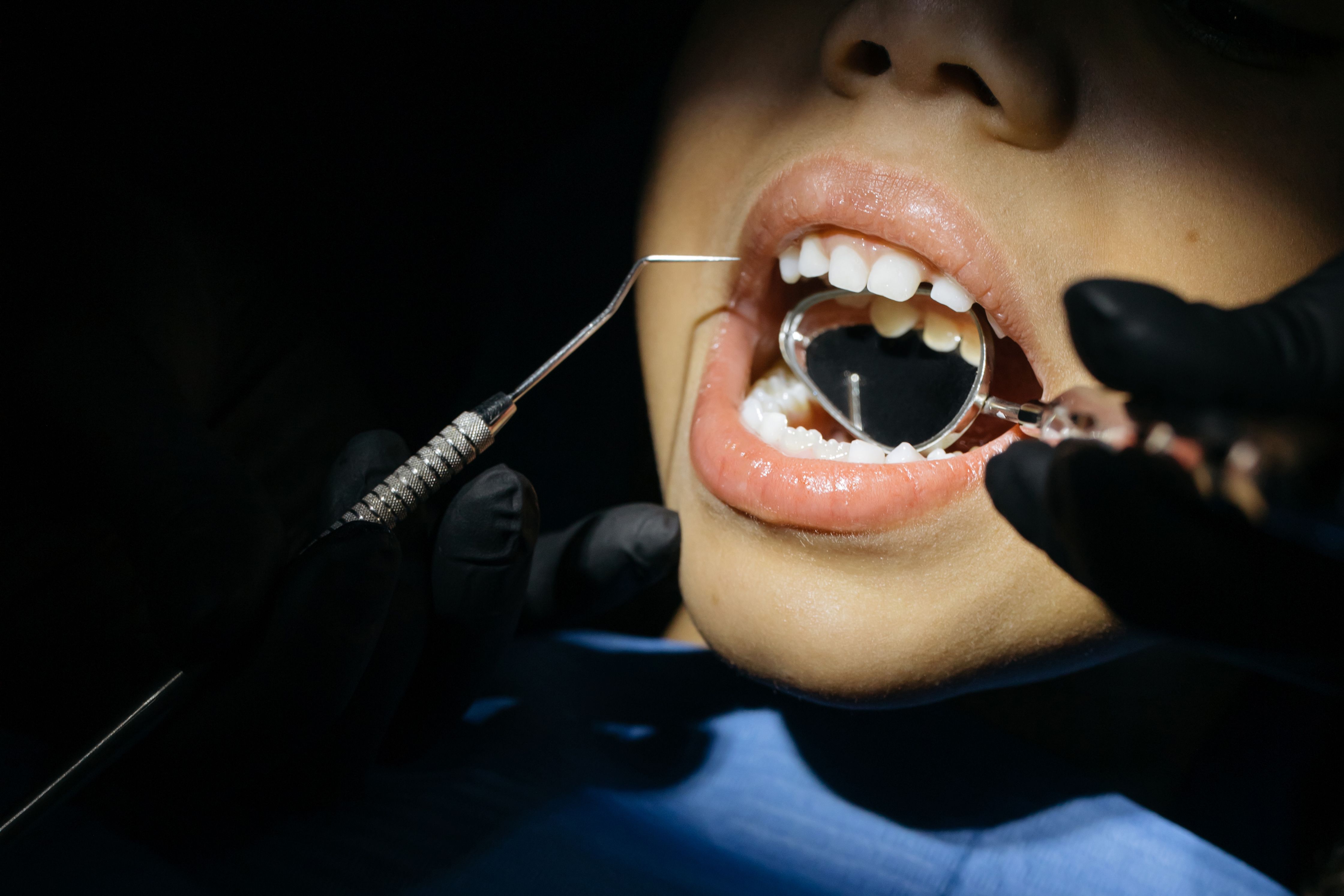 Photo Patient Receiving Dental Examination With Mirror And Explorer