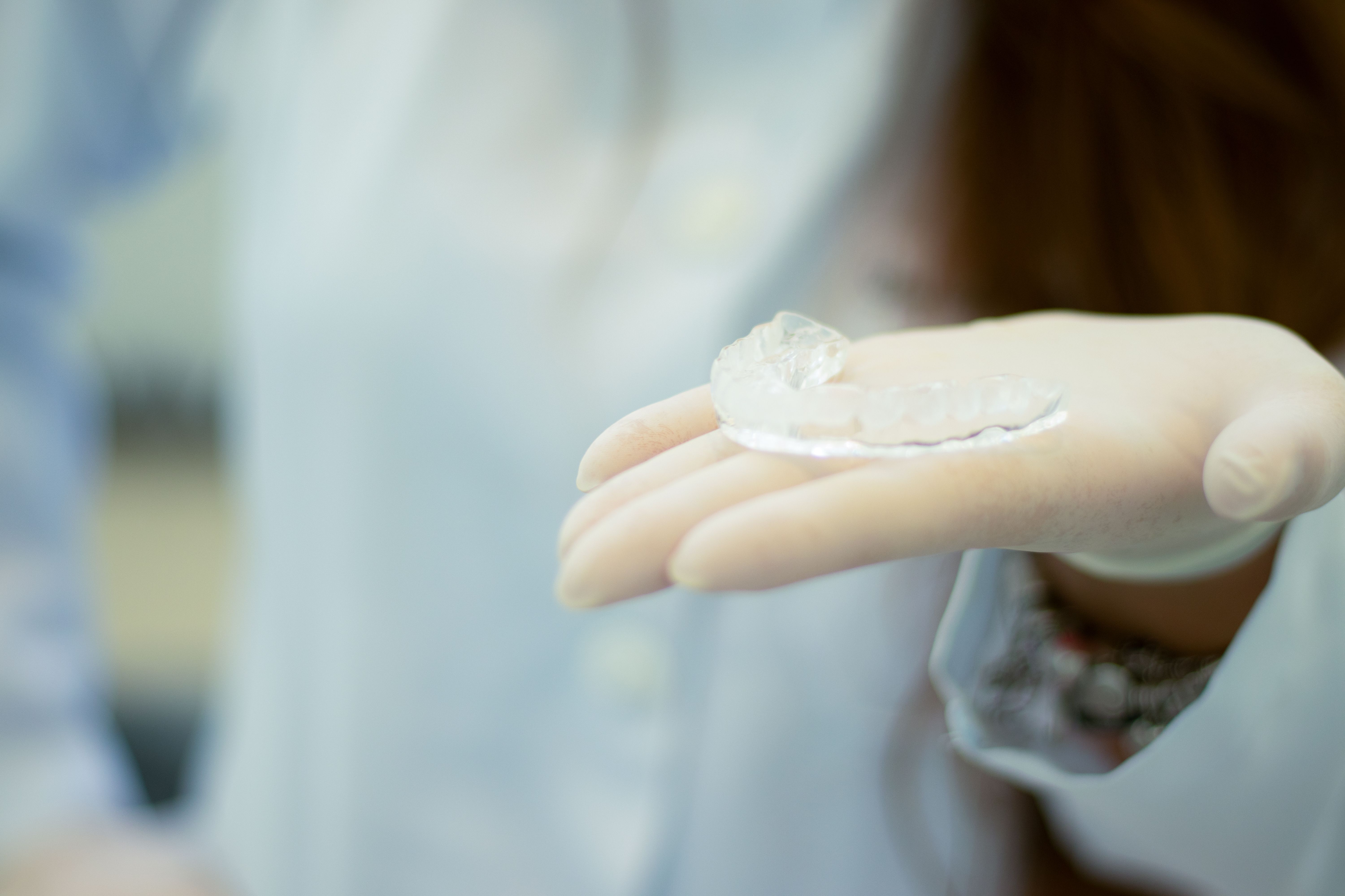 Photo Gloved Hand Holding A Clear Dental Aligner